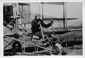 Black and white photograph of Ruth Law, sitting in a Curtiss Pusher airplane