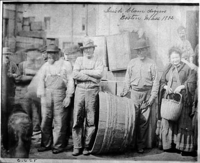 Group of clam diggers on a wharf in Boston, standing around boxes, buckets and barrels.
