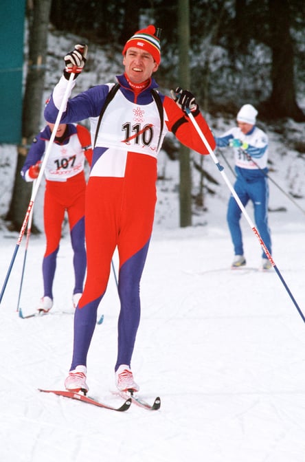 Photograph of several men skiing in the biathlon competition