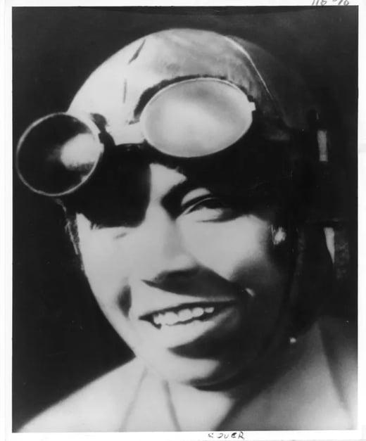 Black and white photograph of Bessie Coleman, wearing a flying helmet and googles
