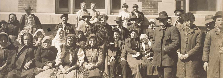 Photograph of a Group of Immigrants Outside a Building on Ellis Island [cropped]