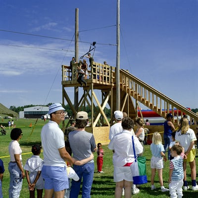 Strapped into a parachute harness, a visitor leaps from the jump tower during the fort's Armed Forces Day open house